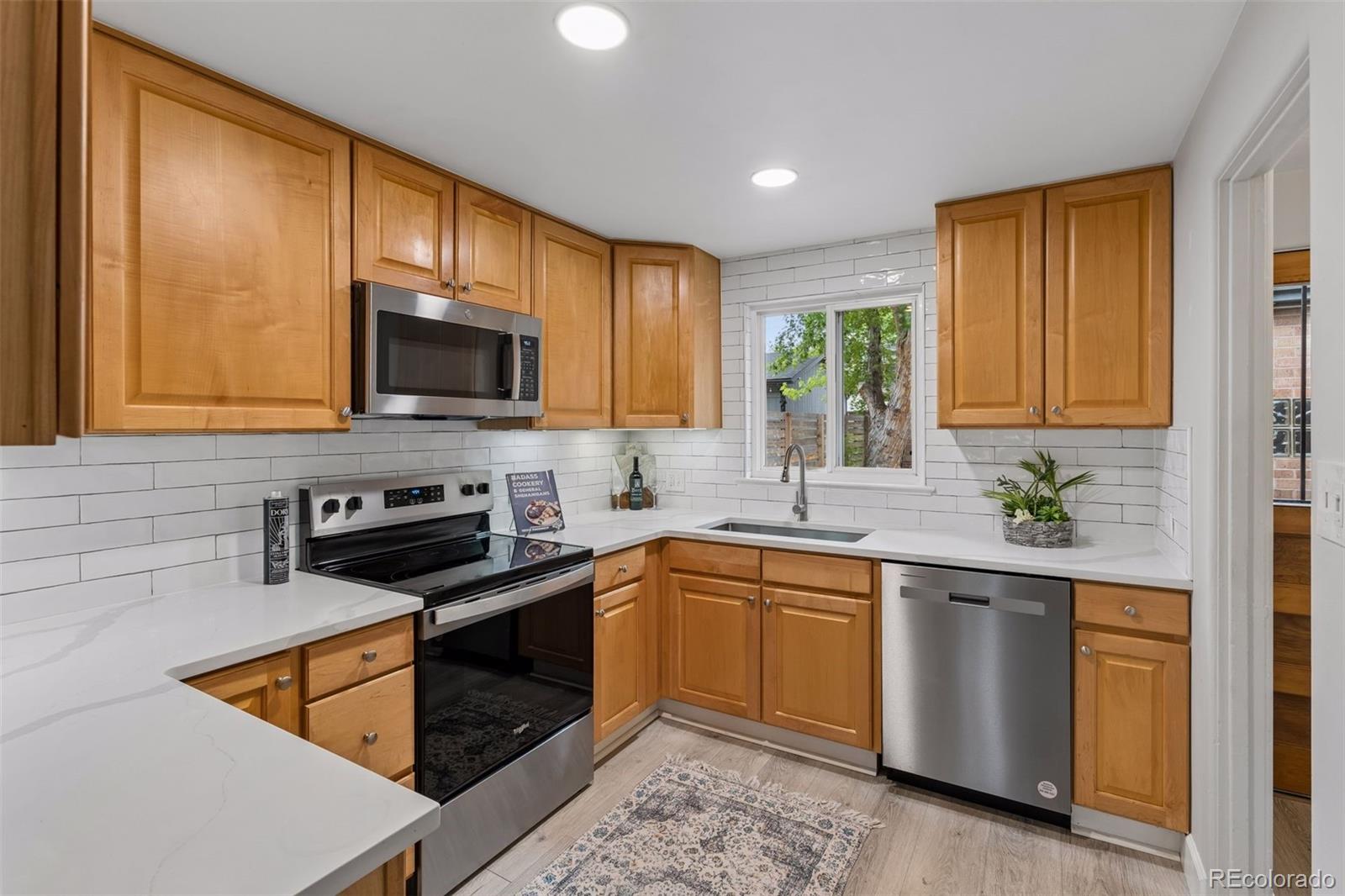 2255 Meade Street Denver, CO 80211 - Photo 8 of 30 a kitchen with stainless steel appliances granite countertop wooden cabinets a stove top oven a sink and dishwasher