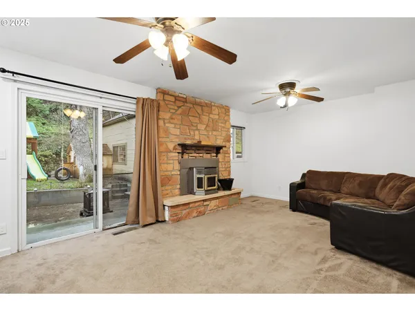 a living room with furniture a ceiling fan and a fireplace