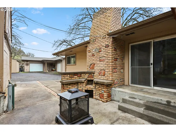 a backyard of a house with barbeque oven table and chairs