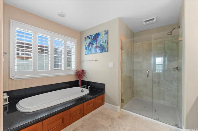 a bathroom with a granite countertop sink and a bathtub