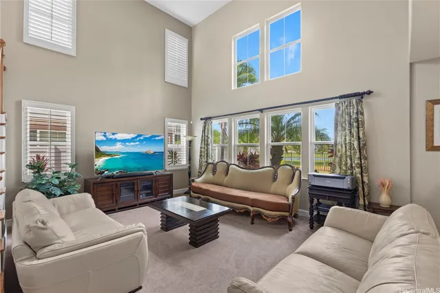 a living room with furniture a flat screen tv and a floor to ceiling window