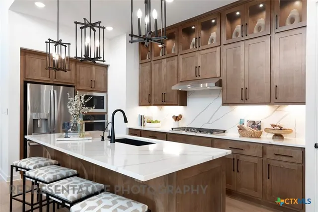 a kitchen with granite countertop a sink stainless steel appliances and cabinets