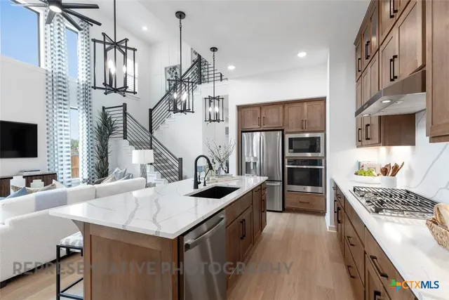 a kitchen with stainless steel appliances granite countertop a sink stove and refrigerator