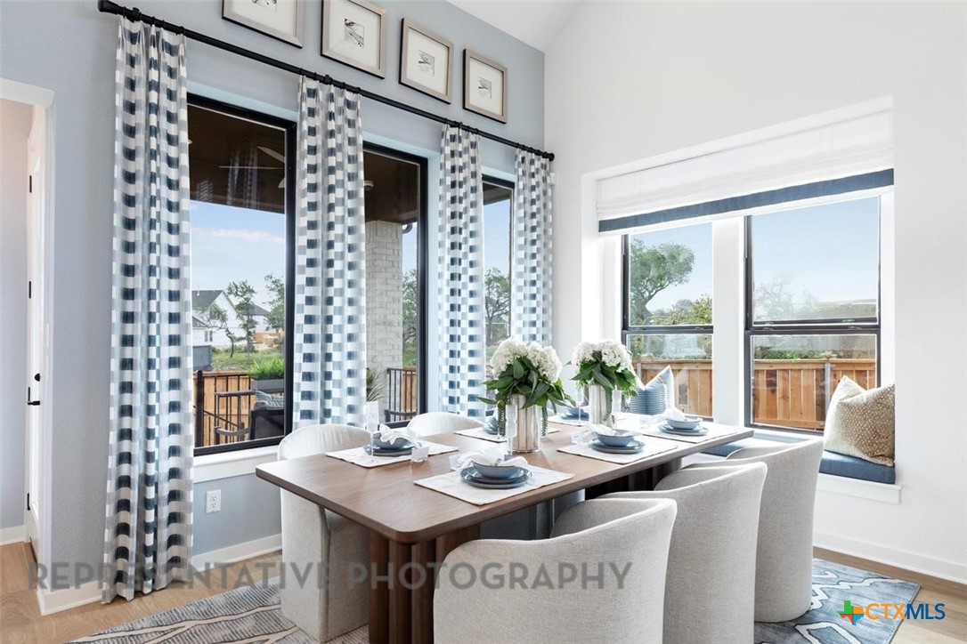 244 Basket Flower Loop Kyle, TX 78640 - Photo 9 of 34 a view of a dining room with furniture large windows and a chandelier