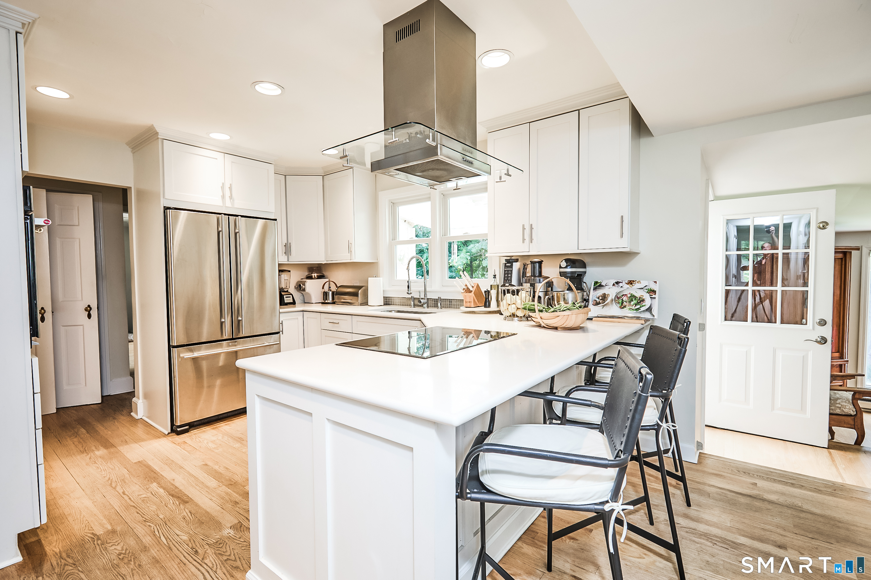 188 Compo Road South Westport, CT 06880 - Photo 13 of 39 a kitchen with stainless steel appliances a refrigerator a stove a sink dishwasher a dining table and chairs with wooden floor