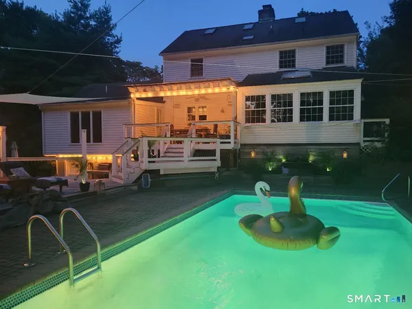 a view of a house with backyard swimming pool and sitting area