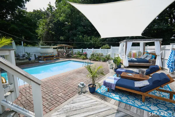 a view of a patio with chairs and iron fence