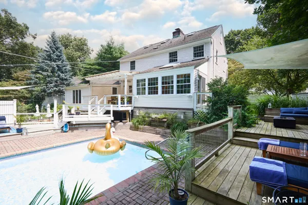 a view of a patio with couches table and chairs with wooden fence