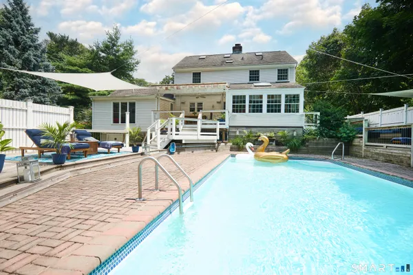 a view of a house with swimming pool and sitting area