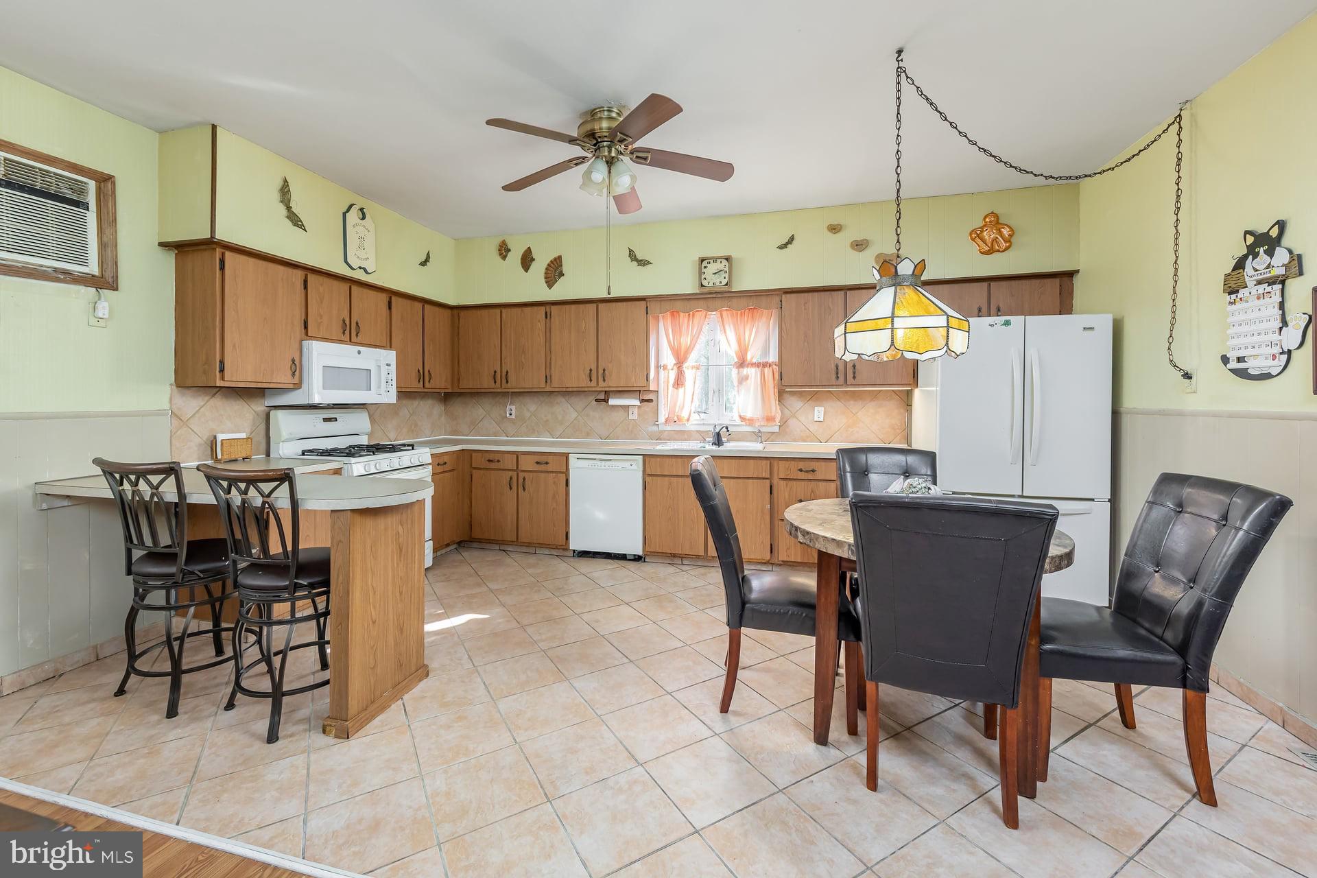 40 West Kings Highway Mount Ephraim, NJ 08059 - Photo 9 of 31 a kitchen with stainless steel appliances granite countertop a sink a stove a dining table and chairs with wooden floor