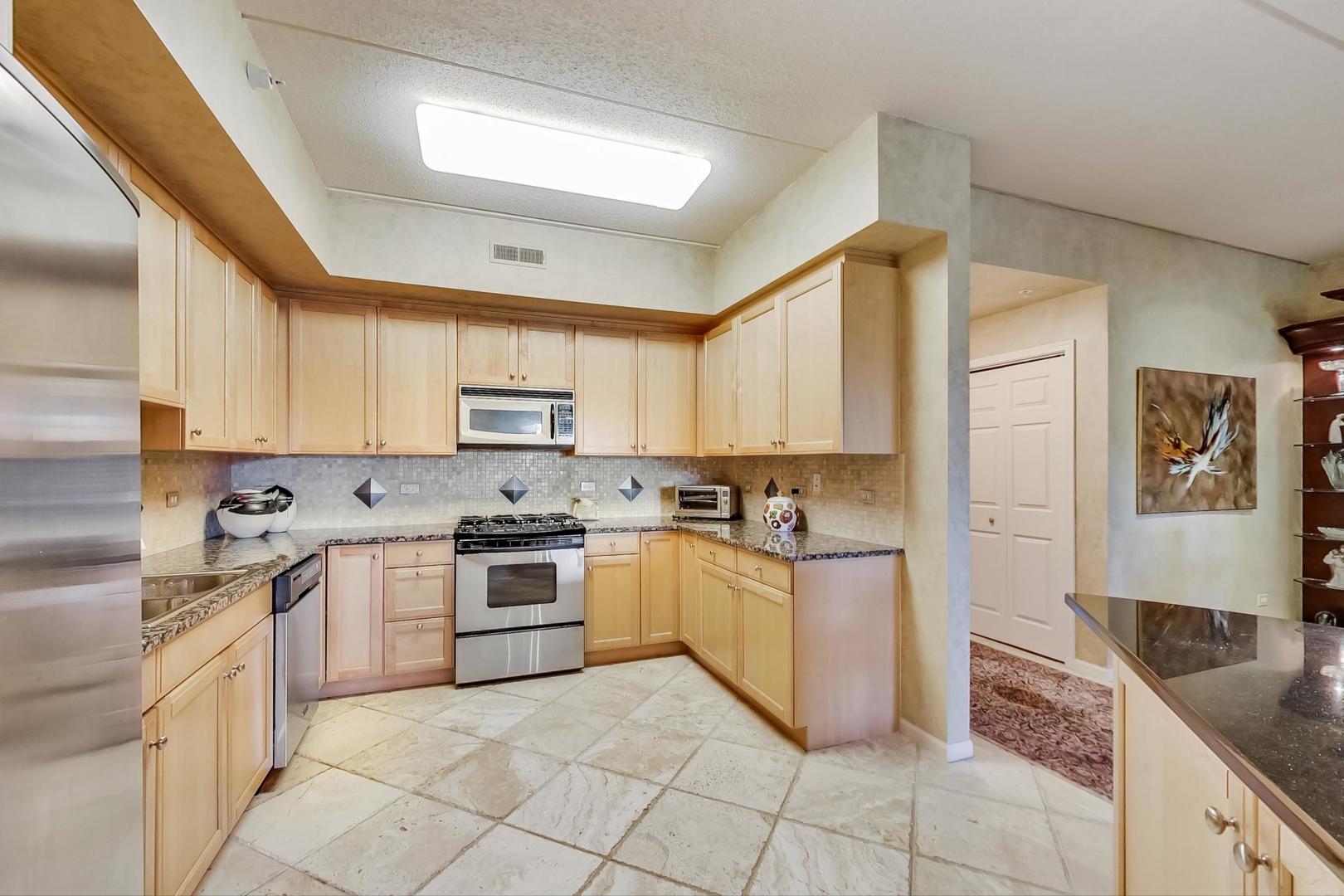 950 Augusta Way, Unit 204 Highland Park, IL 60035 - Photo 12 of 36 a kitchen with stainless steel appliances granite countertop a stove top oven a sink a counter space and cabinets