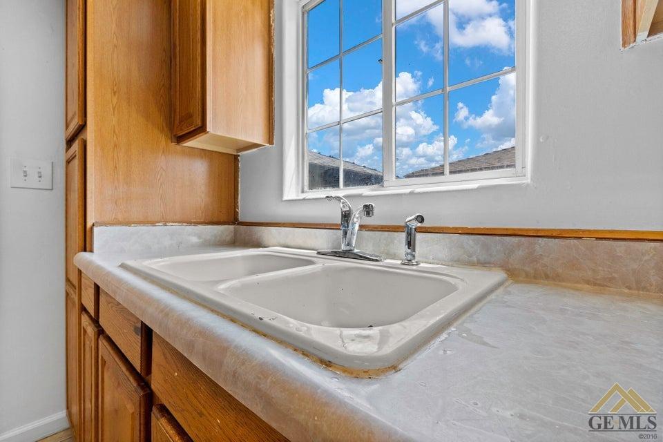 Undisclosed Address Bakersfield, CA 93308 - Photo 14 of 24 a bathroom with a granite countertop sink and mirror next to a window