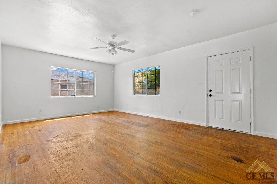 Undisclosed Address Bakersfield, CA 93308 - Photo 21 of 24 an empty room with wooden floor ceiling fan and windows