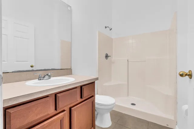 a bathroom with a granite countertop sink a toilet and shower