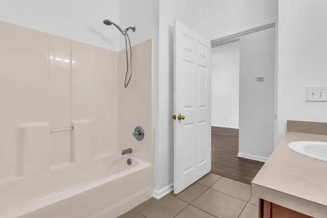 a bathroom with a tub shower and a sink