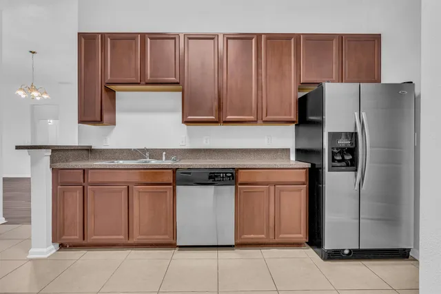 a kitchen with stainless steel appliances granite countertop a refrigerator and a stove top oven