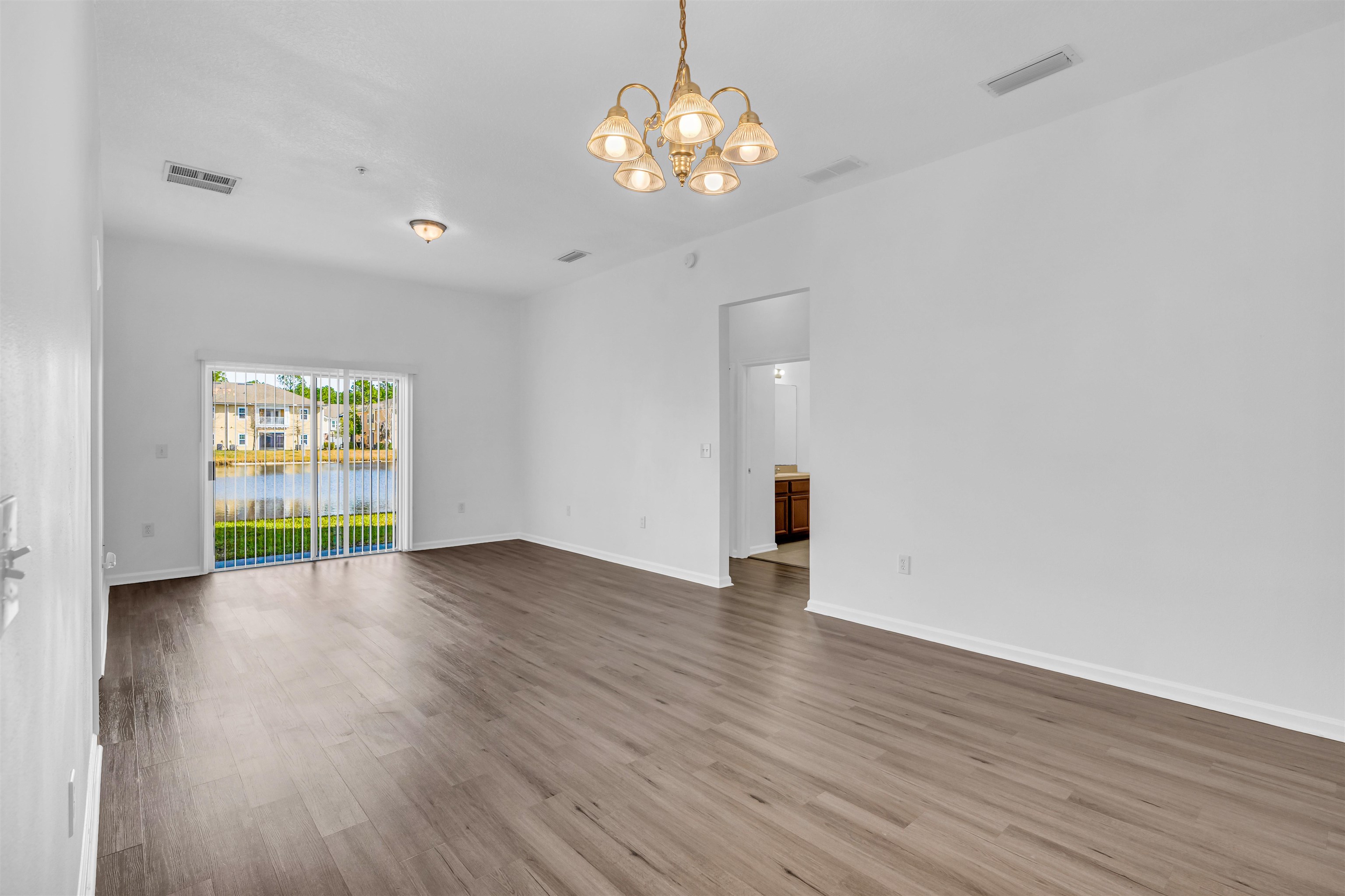 406 Golden Lake Loop St. Augustine, FL 32084 - Photo 6 of 51 a view of an empty room with wooden floor and a window