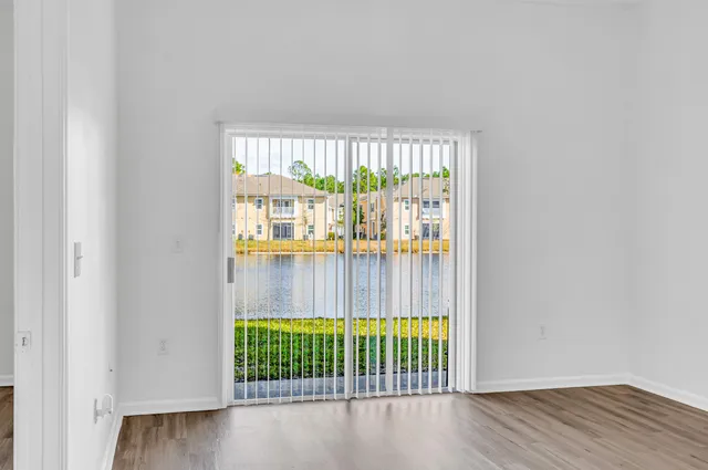 an empty room with wooden floor and balcony