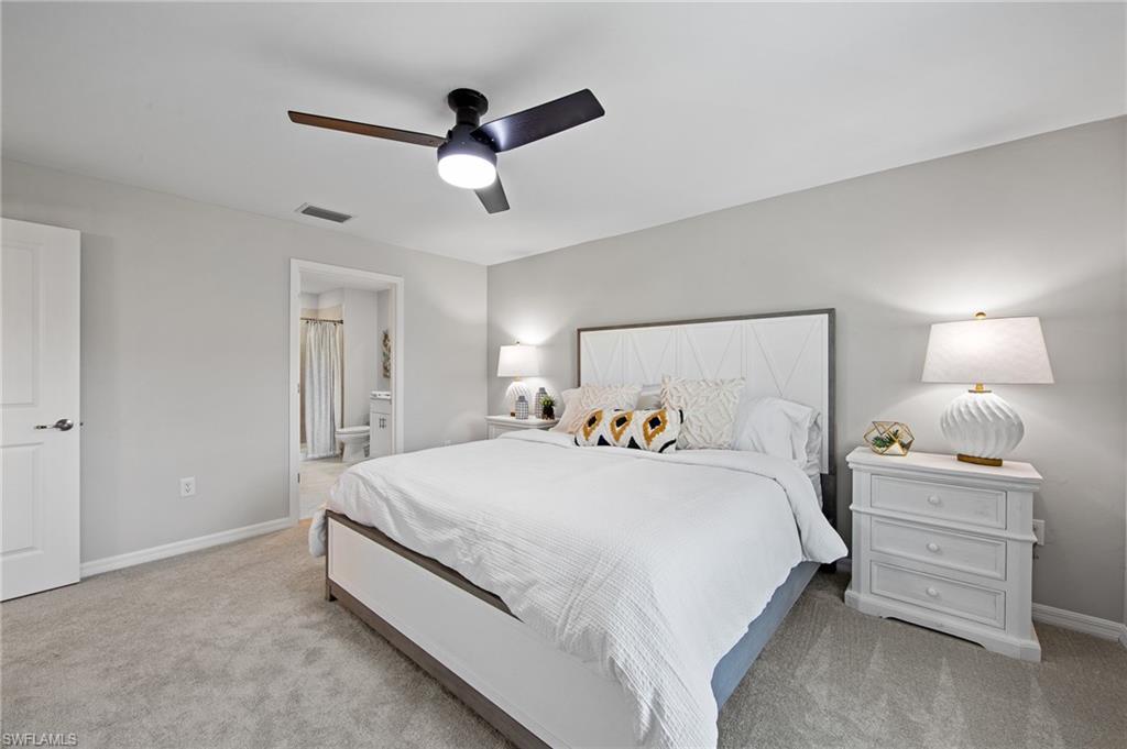 4139 Tulia Way North Fort Myers, FL 33917 - Photo 21 of 32 a bedroom with a bed and a lamp