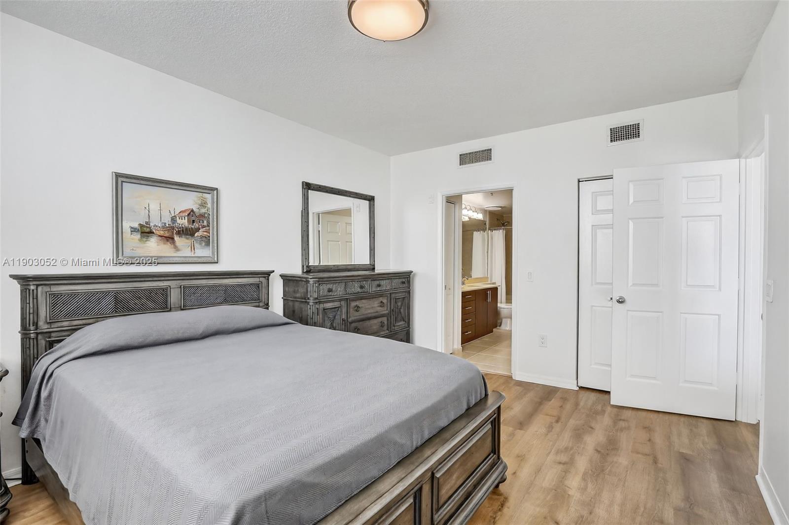 2421 Northeast 65th Street, Unit 508 Fort Lauderdale, FL 33308 - Photo 13 of 29 a bedroom with a large bed and a chandelier