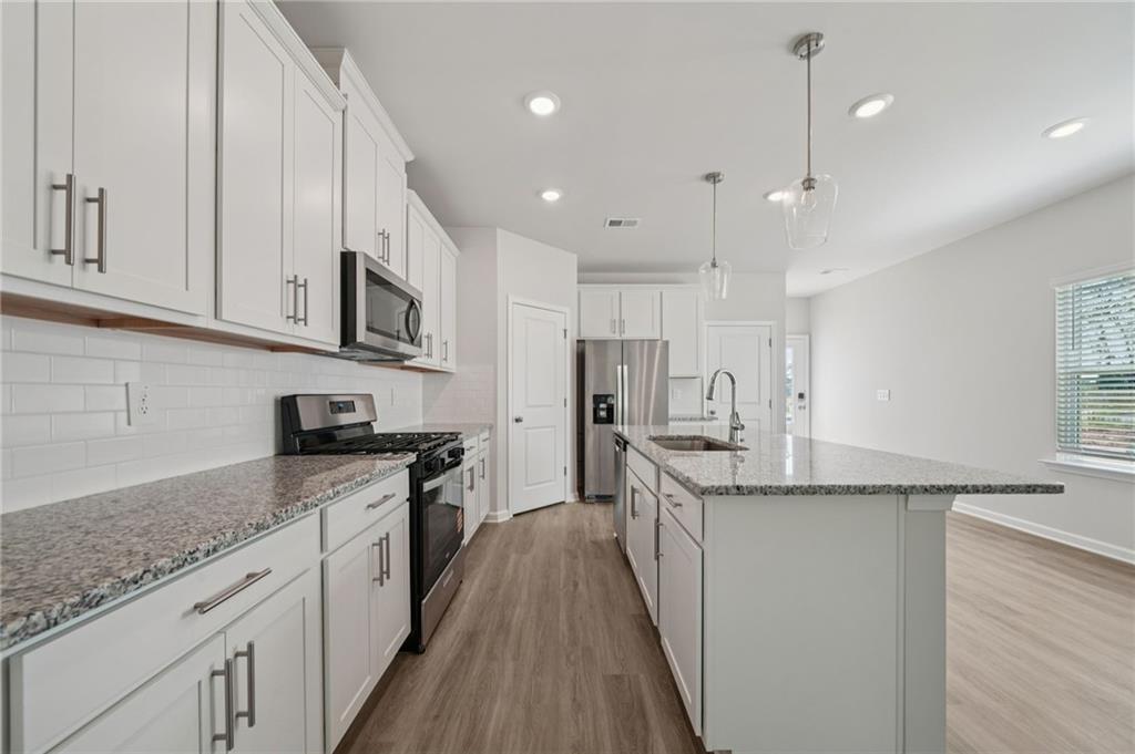 7830 Marie Way Fairburn, GA 30213 - Photo 11 of 30 a kitchen with stainless steel appliances granite countertop a sink stove and refrigerator