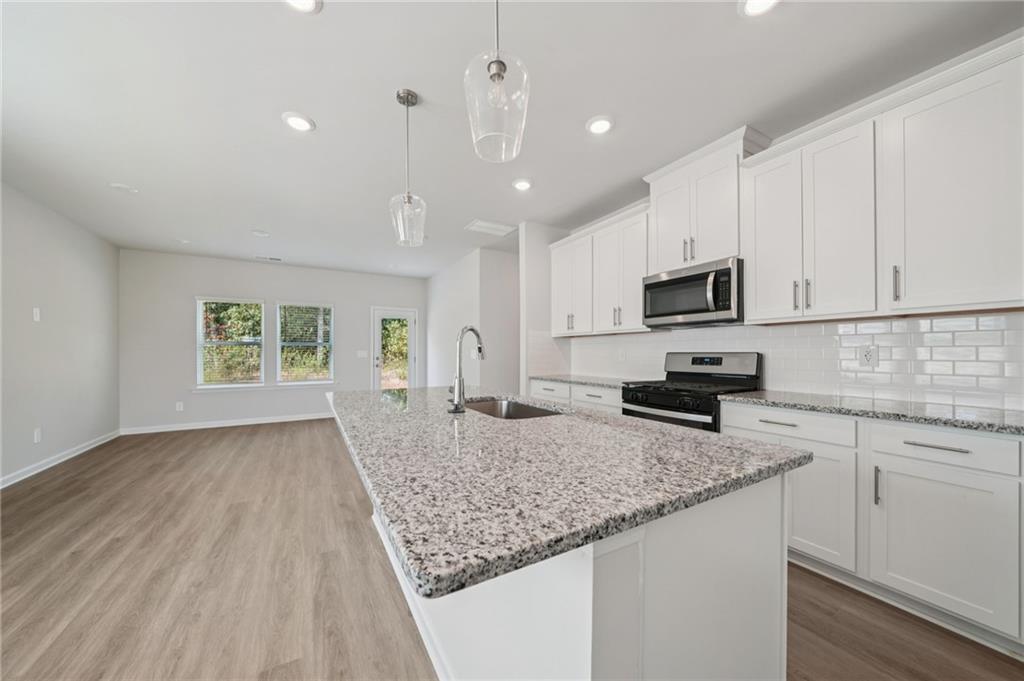 7830 Marie Way Fairburn, GA 30213 - Photo 12 of 30 a kitchen with sink refrigerator and microwave