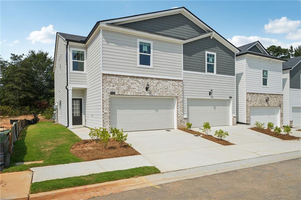 7830 Marie Way Fairburn, GA 30213 - Photo 2 of 30 a front view of a house with a yard and garage