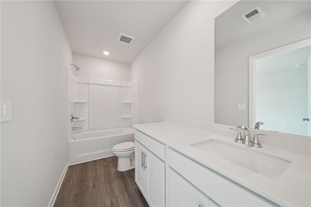 7830 Marie Way Fairburn, GA 30213 - Photo 23 of 30 a bathroom with a sink a toilet and a large mirror