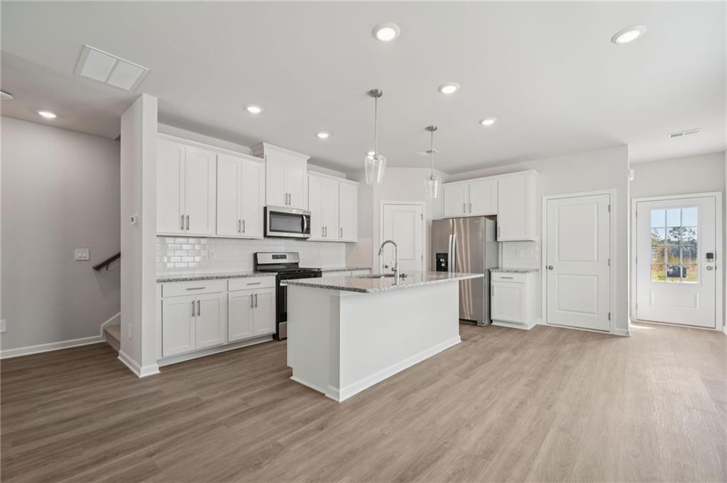 7830 Marie Way Fairburn, GA 30213 - Photo 9 of 30 a kitchen with white cabinets and stainless steel appliances