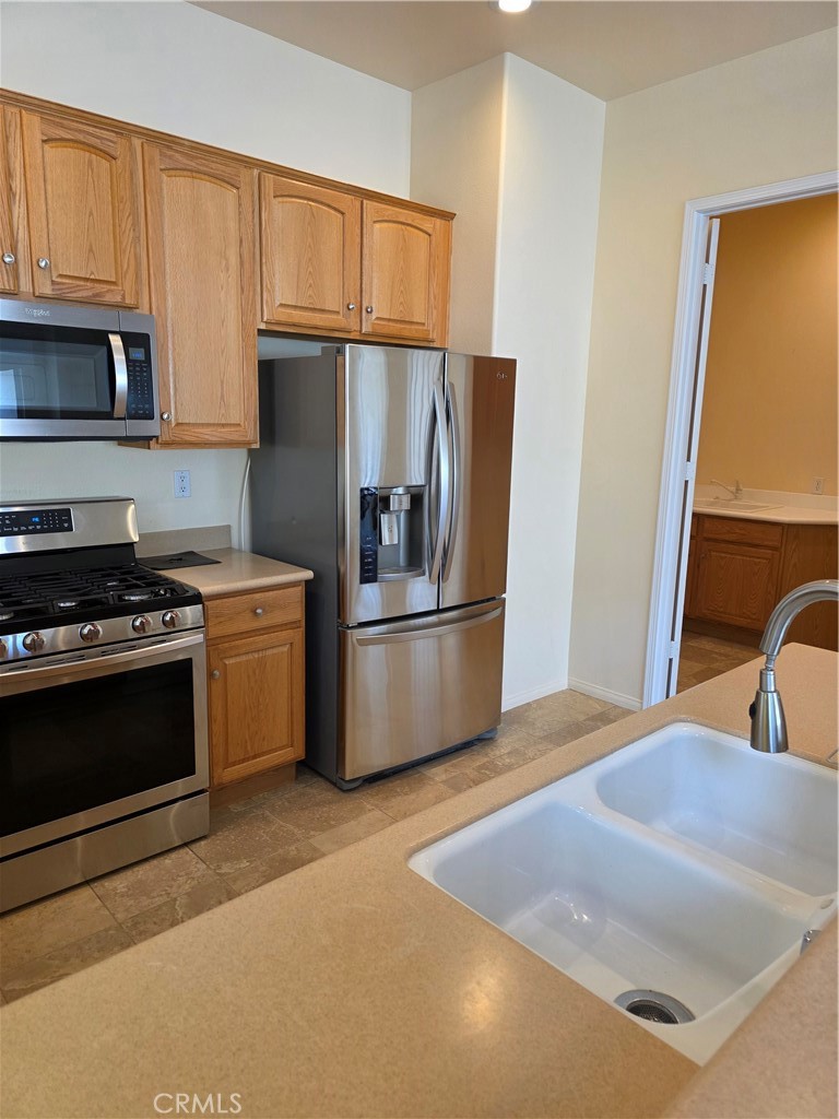 924 Brentwood Road Beaumont, CA 92223 - Photo 11 of 41 a kitchen with stainless steel appliances a refrigerator a sink a stove and cabinets