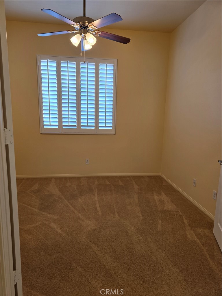 924 Brentwood Road Beaumont, CA 92223 - Photo 14 of 41 en empty room with windows and ceiling fan