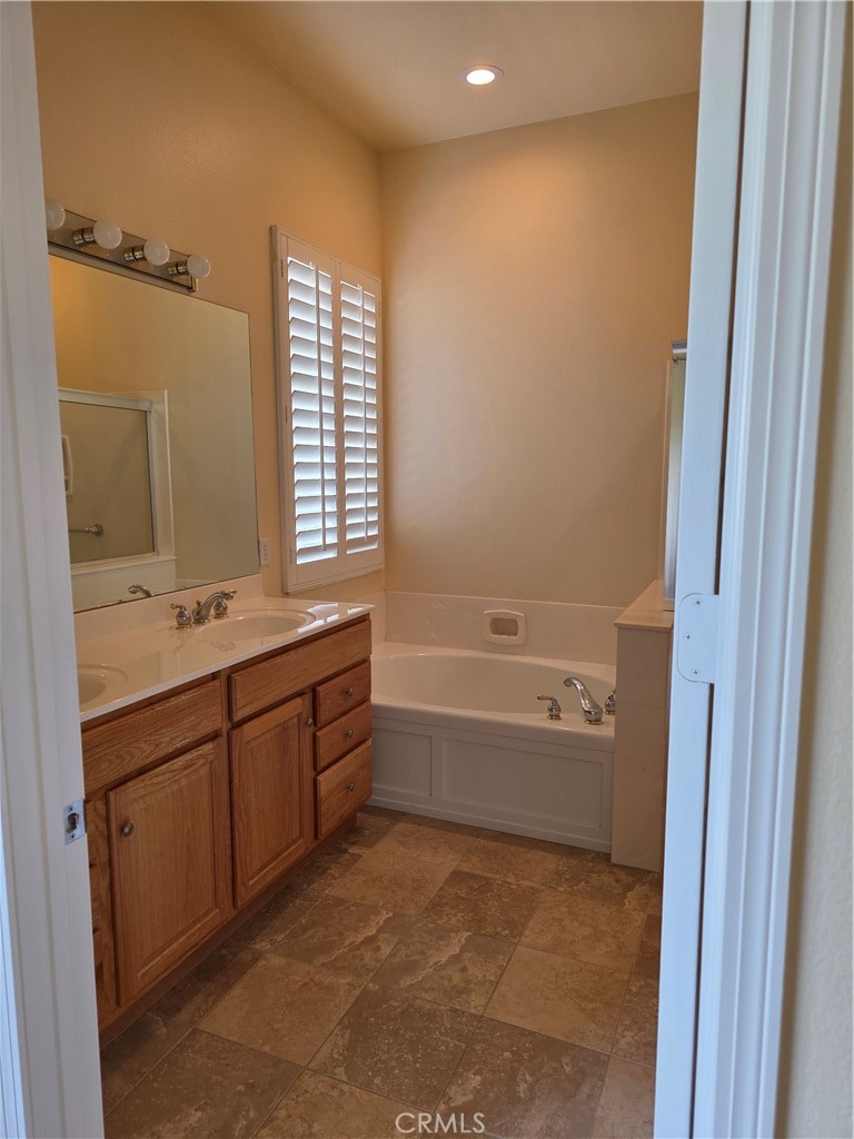 924 Brentwood Road Beaumont, CA 92223 - Photo 25 of 41 a bathroom with a tub sink and mirror