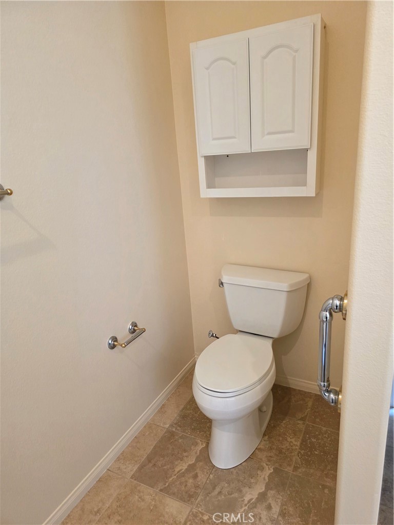 924 Brentwood Road Beaumont, CA 92223 - Photo 27 of 41 a white toilet sitting next to a bathroom sink