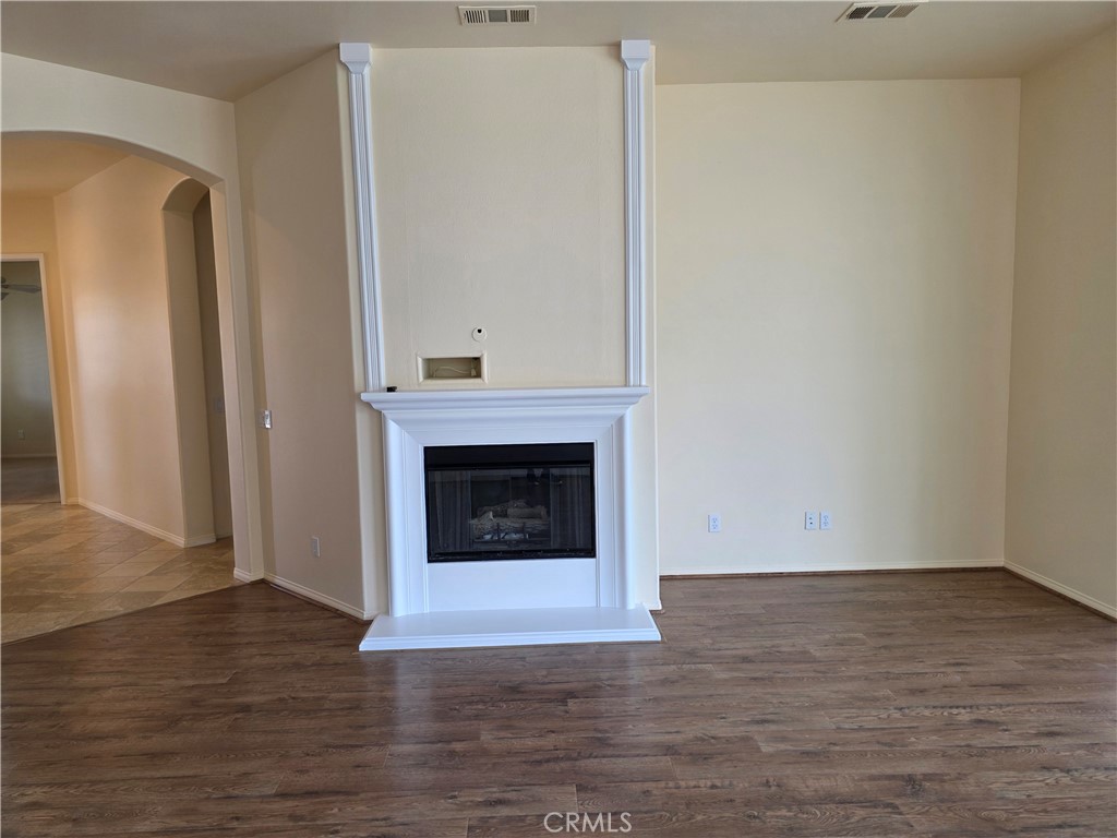 924 Brentwood Road Beaumont, CA 92223 - Photo 7 of 41 a view of a livingroom with wooden floor and a fireplace