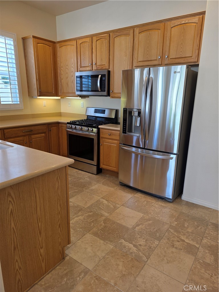 924 Brentwood Road Beaumont, CA 92223 - Photo 9 of 41 a kitchen with granite countertop a refrigerator stove and microwave