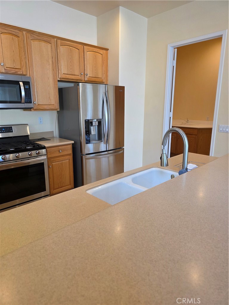 924 Brentwood Road Beaumont, CA 92223 - Photo 10 of 41 a kitchen with a refrigerator sink and white cabinets