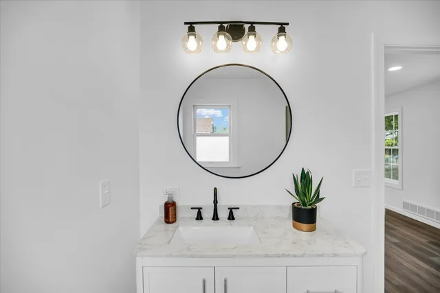 an empty room with wooden floor and ceiling fan