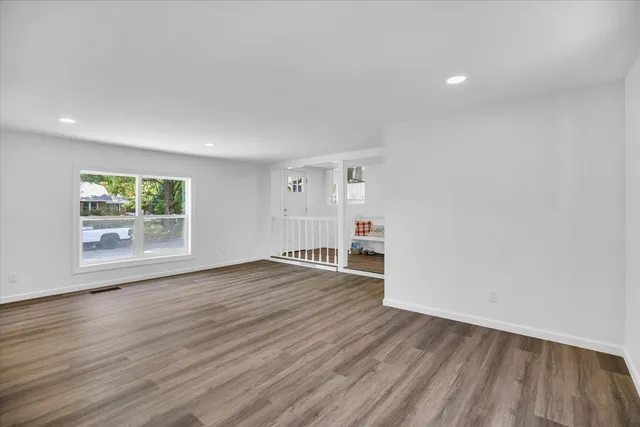 a view of an empty room with wooden floor