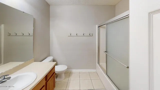 an empty room with a ceiling fan and window