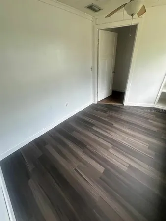 a view of empty room with wooden floor
