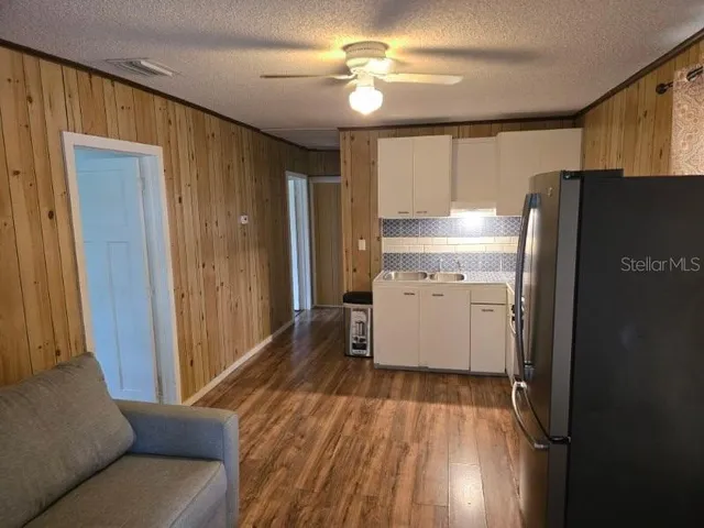 a kitchen with a refrigerator a sink and cabinets