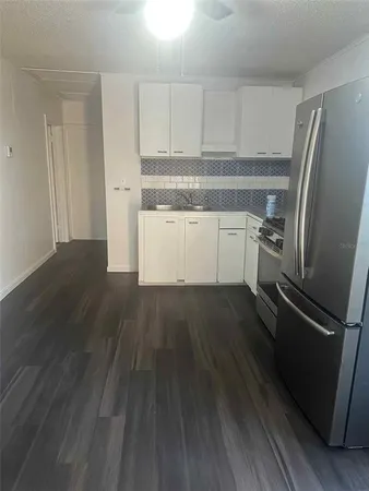 a kitchen with wooden floors and refrigerator