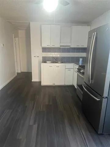 a kitchen with wooden floors and refrigerator