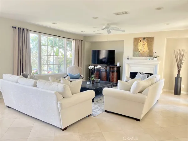 a living room with furniture a flat screen tv and a fireplace