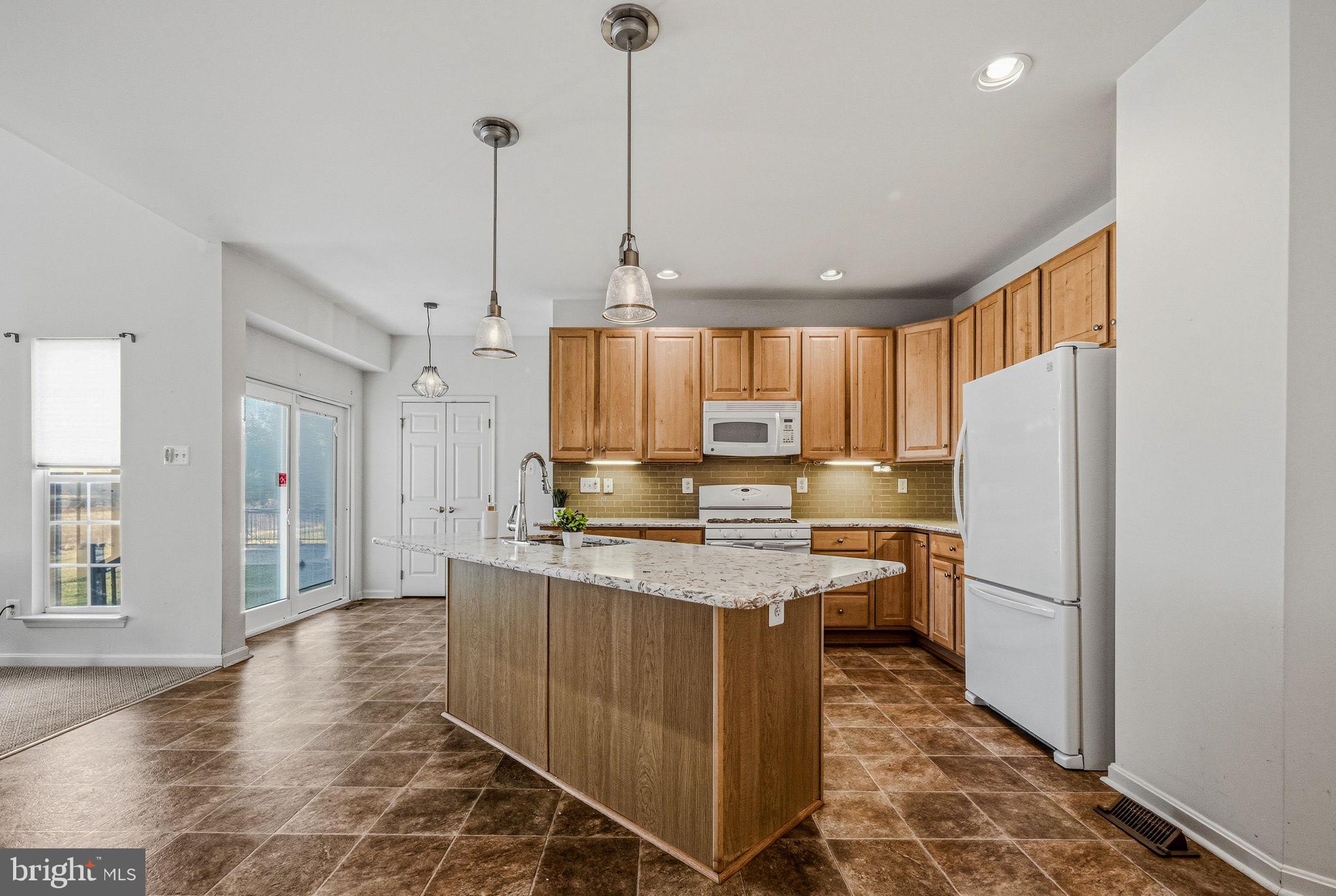 325 Pierce Run Newark, DE 19702 - Photo 9 of 42 a kitchen with kitchen island a stove a refrigerator a sink dishwasher with a dining table and chairs