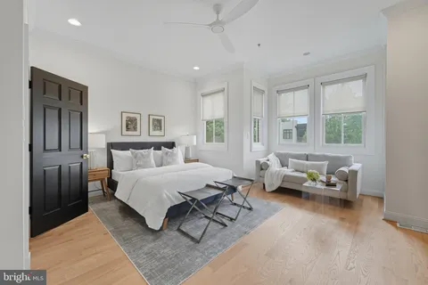 a spacious bedroom with a bed couch and a window