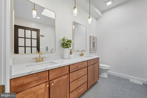 a bathroom with a double vanity sink a toilet and a mirror