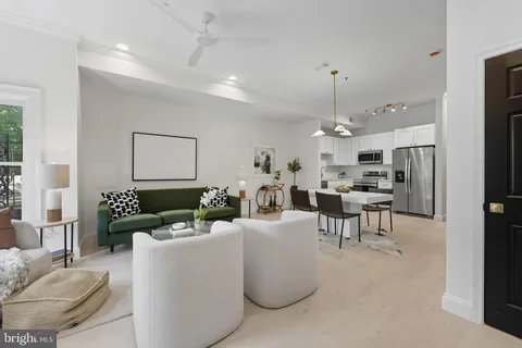 a living room with furniture kitchen and a chandelier