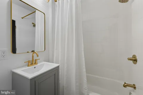 a bathroom with a sink a mirror and shower