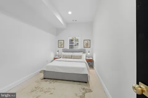 a spacious bedroom with a bed and a night stand